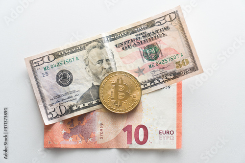 Biktcoin coin lies on paper euro and dollar banknotes. Concept of virtual currency in exchange