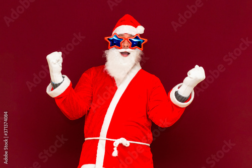 Holly jolly x-mas, confidence, magic, triumph concept. Cool funny playful biddle aged man shows win gesture photo