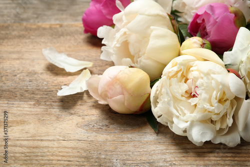 Beautiful peony flowers on wooden background, closeup © New Africa