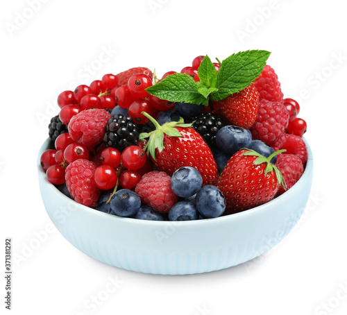 Mix of different fresh berries and mint in bowl on white background