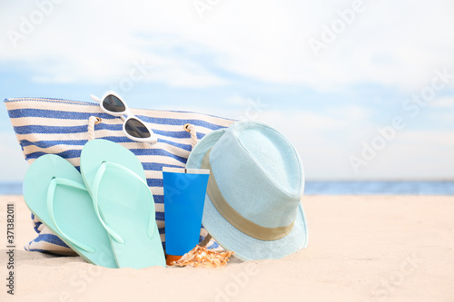 Fototapeta Naklejka Na Ścianę i Meble -  Different stylish beach objects on sand near sea