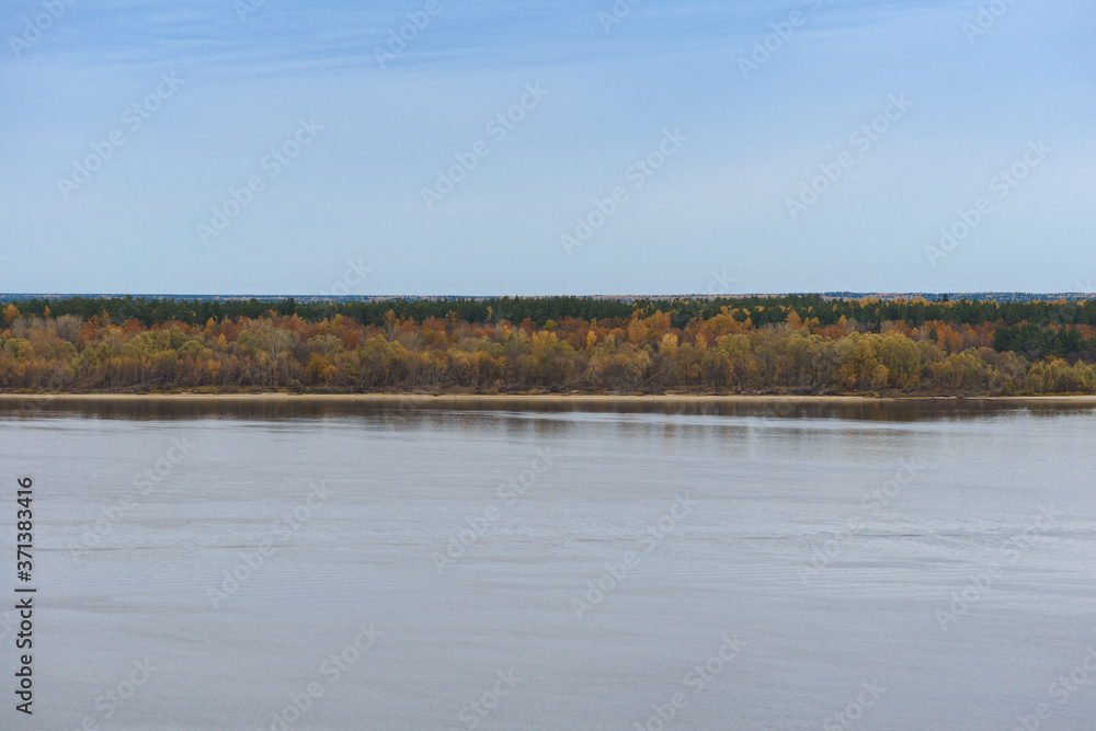 Distant sandy riverbank with autumn forest on a cloudy afternoon Distant sandy riverbank with autumn forest on a cloudy afternoon