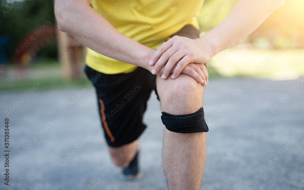 Man exercising lunges with protective knee bandage, close up Man exercising lunges with protective knee bandage, close up