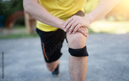 Man exercising lunges with protective knee bandage, close up