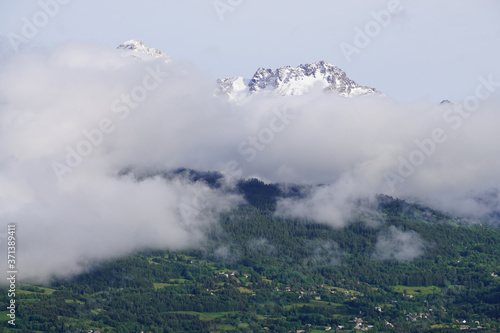 clouds over a snowy mountain in the french alps