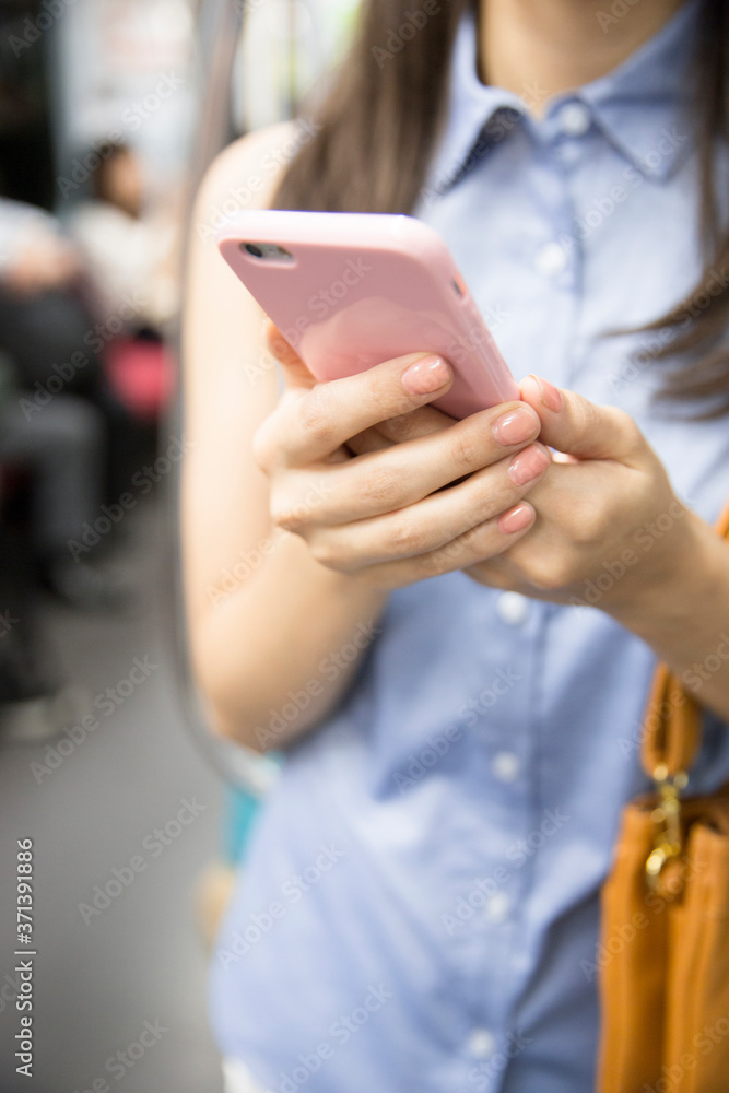 電車でスマホを見る女性 電車でスマホを見る女性