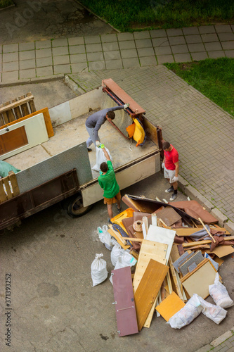 Wallpaper Mural Workers load old furniture into the back of a truck to transport Torontodigital.ca
