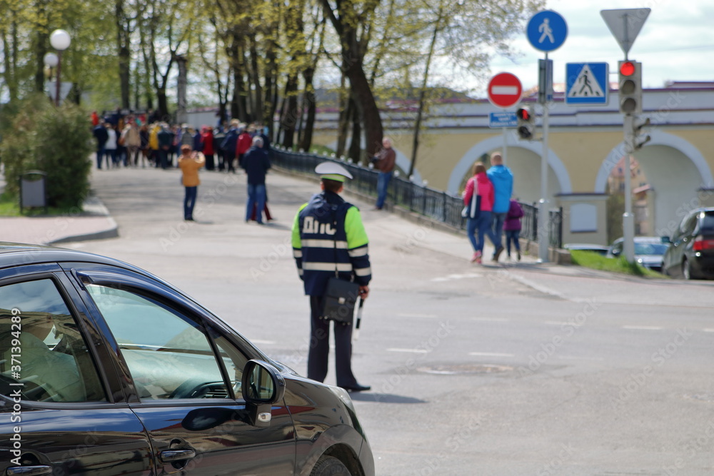 Street in rodno, Belarus, black car, policeman and people in soft focus