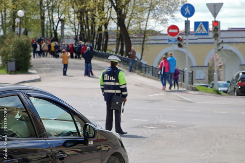 Street in rodno, Belarus, black car, policeman and people in soft focus © Wioletta