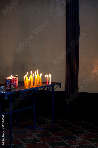 Candles and offerings at altar in Maximon San Simon temple near Antigua Guatemala photo