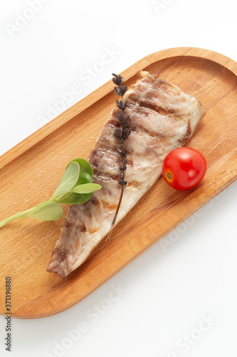 Fish fried on the grill and served on a plate with fresh vegetables photo