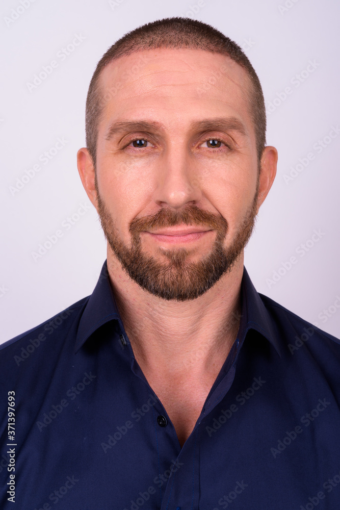 Face of handsome bald bearded businessman looking at camera Face of handsome bald bearded businessman looking at camera