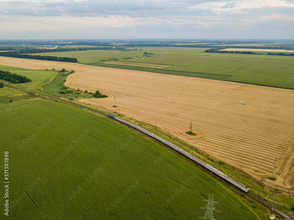 Aerial drone view. The train passes between the fields.