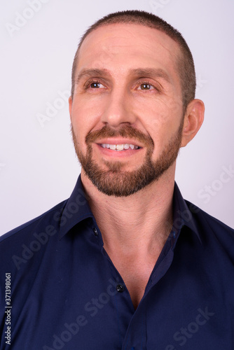 Portrait of happy handsome bald bearded businessman