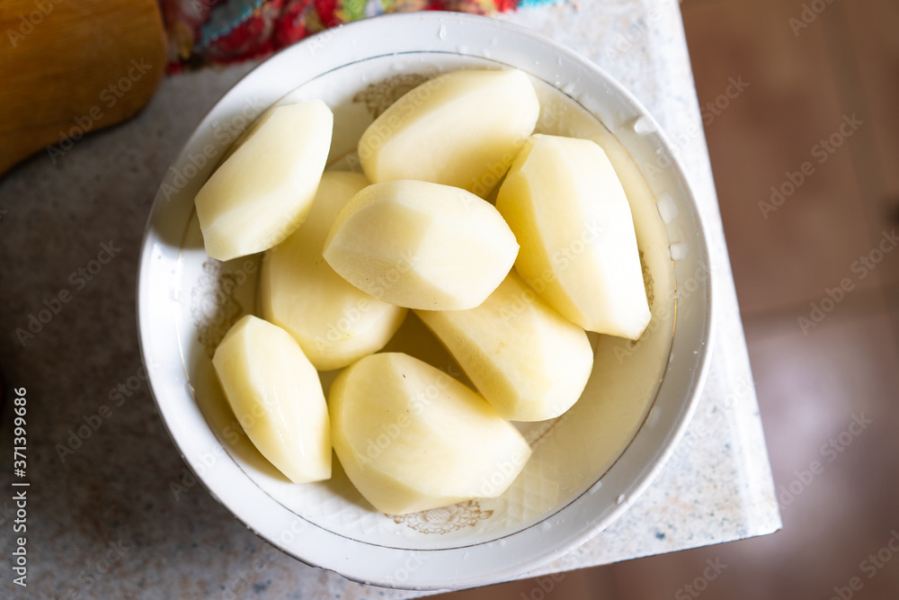 Peeled potatoes are in a plate Peeled potatoes are in a plate