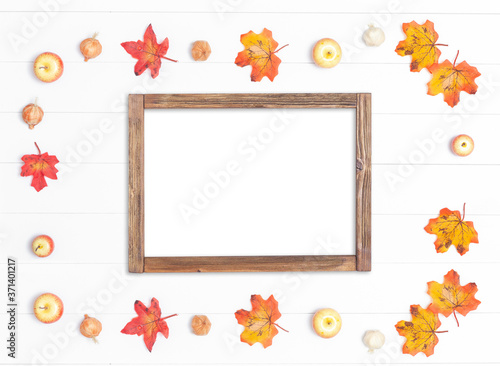 Rough frame made of wood and bright autumn leaves on a white wooden background