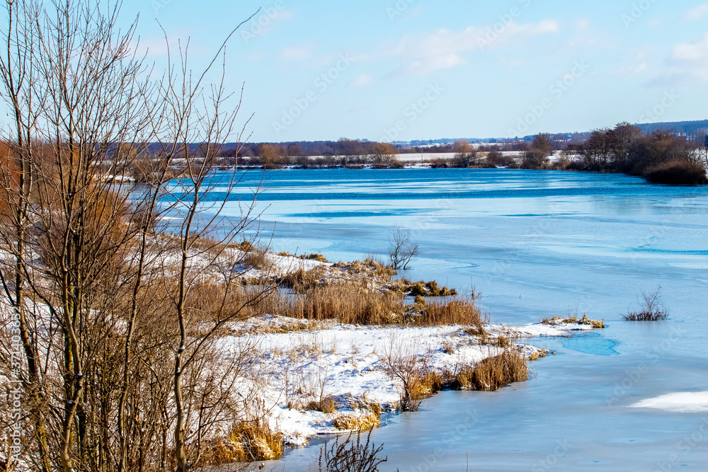 Winter landscape with forest over the river