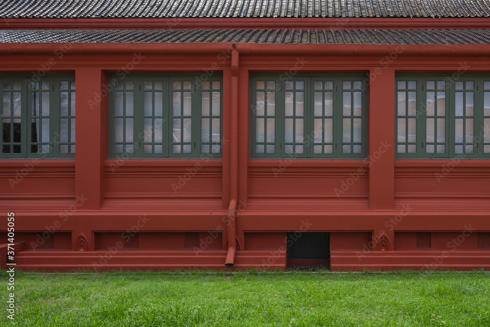 Antique green wooden window with red old building and ancient brown roof tiles interior exterior architecture on green natural grass plant