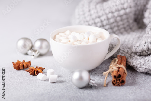 White cup with hot chocolate and marshmallow, sweater, cinnamon. Cozy christmas composition. Hygge concept Soft focus