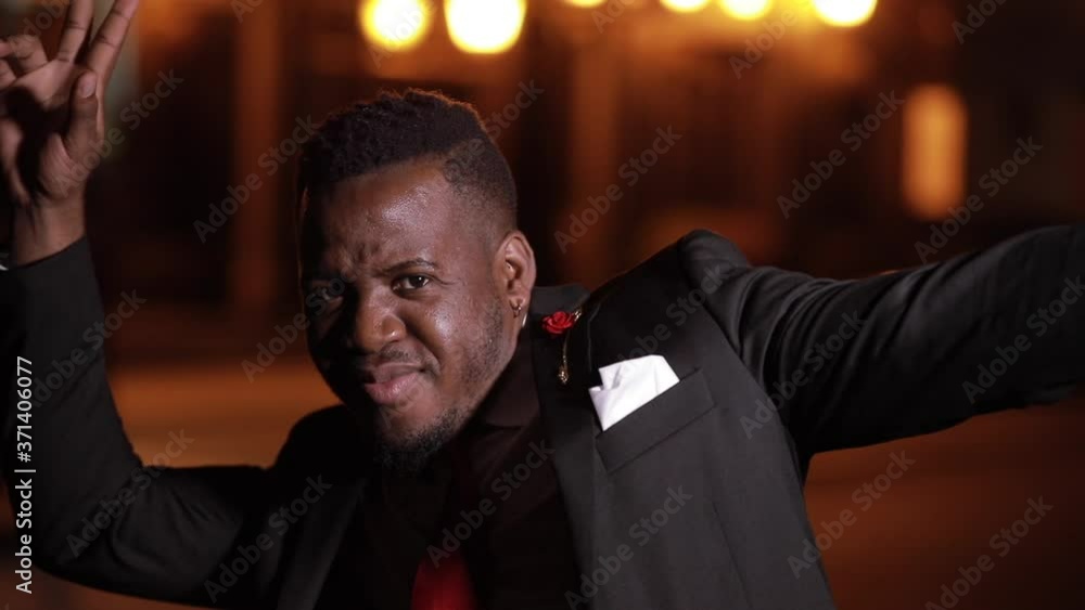 Happy African businessman makes fun in the night city Happy African businessman makes fun in the night city