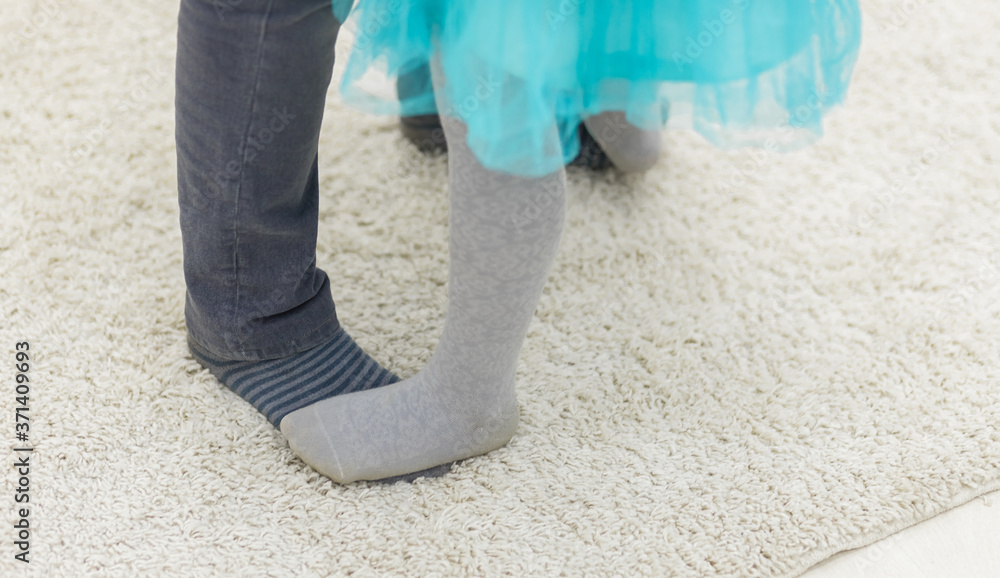 Photo of cropped view daughter's and father's legs. Photo of cropped view daughter's and father's legs.