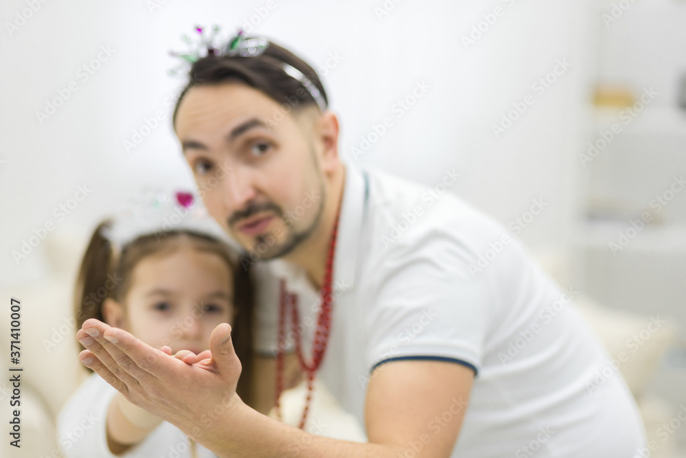 Photo of close up father and daughter dancing wearing crown. Photo of close up father and daughter dancing wearing crown.