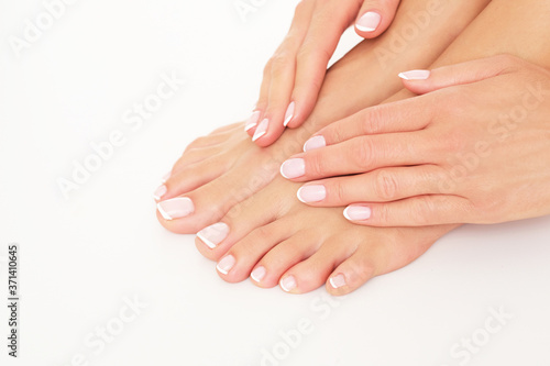 Female hands and feet on white background. Studio shoot.