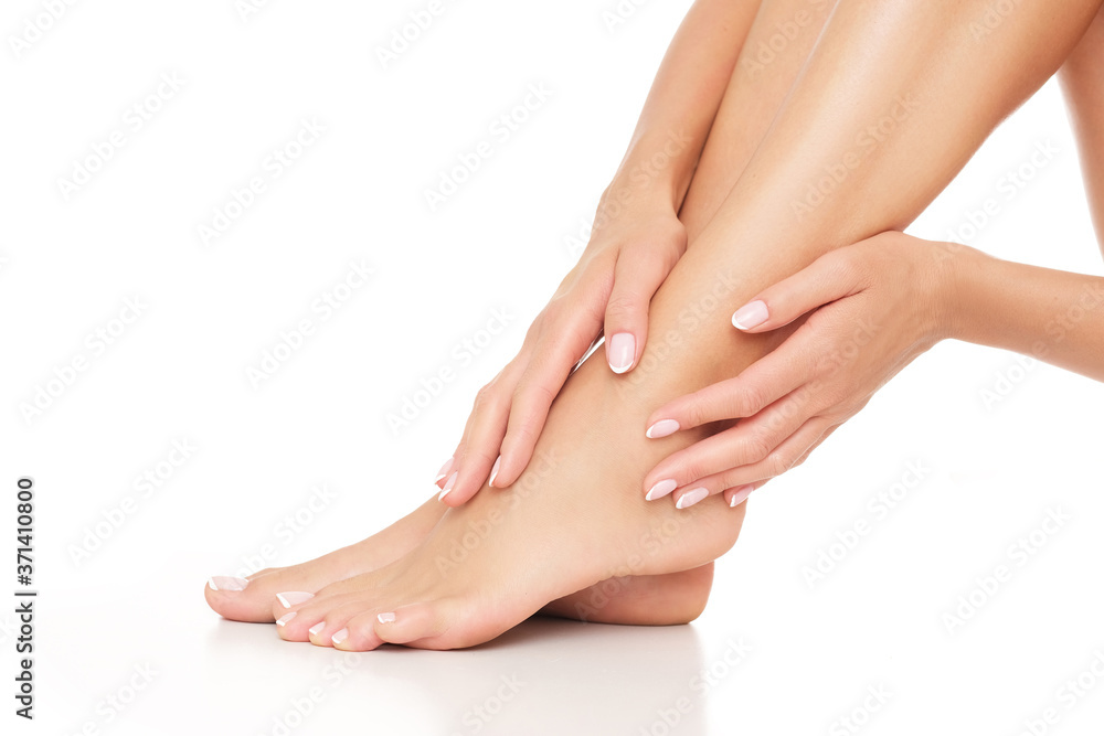 Female hands and feet on white background. Studio shoot. Female hands and feet on white background. Studio shoot.