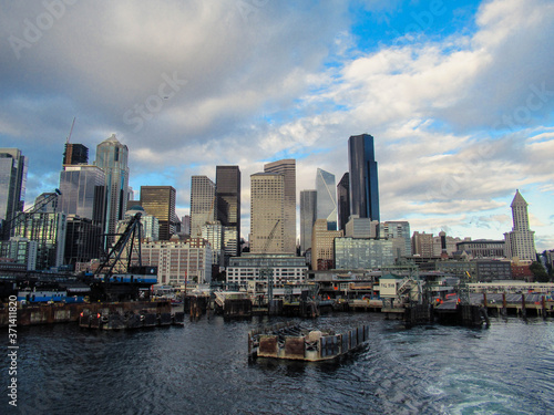 Seattle marina and skyline seen from the sea with some white clouds and blue sky. 