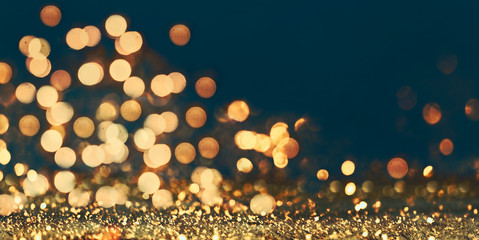 Abstract blur golden glitter border on black background. Luxury card design for new year, christmas and holiday celebration. Party bokeh sparkle confetti textured layout.