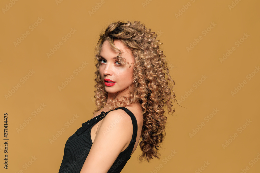 © Fototocam - beautiful young woman with curl hair posing on beige background - Image © Fototocam - beautiful young woman with curl hair posing on beige background - Image