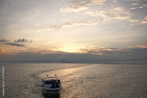 Beautiful sunset over sea with a small boat, Thailand