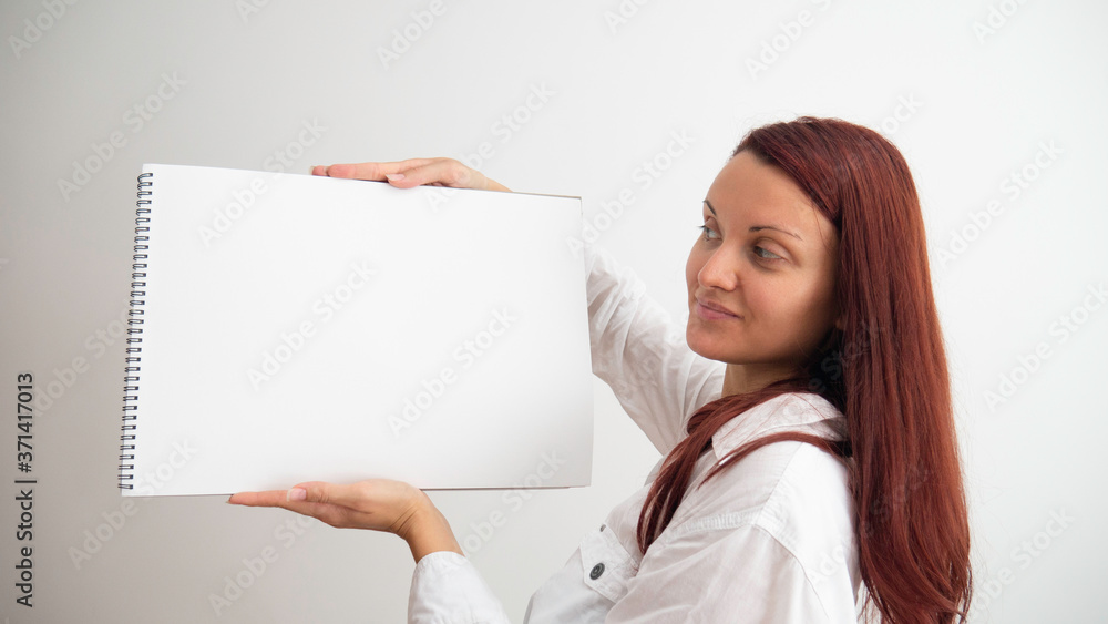 Caucasian woman holds in her hands empty canvas pad. Caucasian woman holds in her hands empty canvas pad.