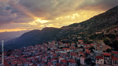 Aerial drone photo of beautiful sunset with golden colours and clouds over picturesque and traditional village of Arachova, Viotia prefecture, Greece