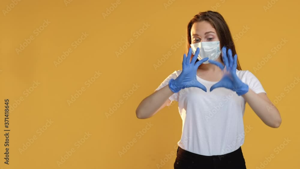 Love signal. Health charity. Optimistic woman in protective face mask gloves blowing air kiss showing heart gesture isolated on beige copy space. Coronavirus pandemic. Devotion message set of 3. Love signal. Health charity. Optimistic woman in protective face mask gloves blowing air kiss showing heart gesture isolated on beige copy space. Coronavirus pandemic. Devotion message set of 3.
