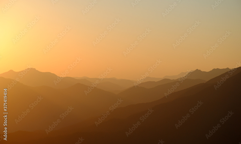 beautiful mountain sunset with fog and peaks