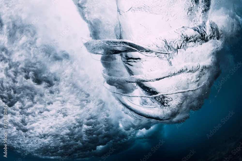 Naklejka Crashing wave with foam and air bubbles underwater. Transparent sea water