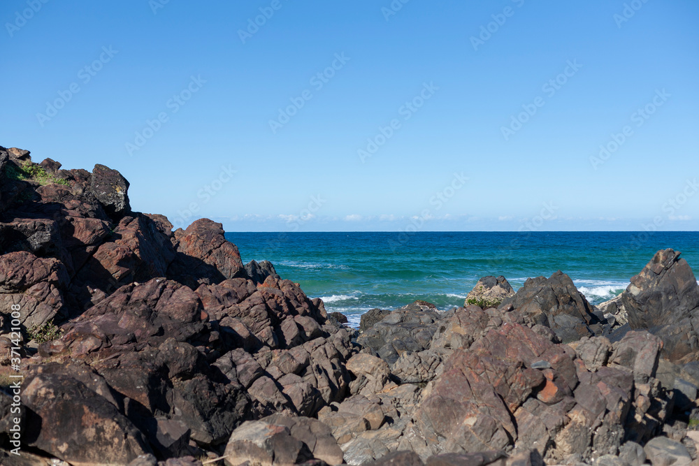 Scenic view of seascape with large rocks on coastline