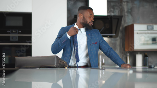 Canvas-taulu Tired afro-american businessman coming home after long workday, loosening tie in