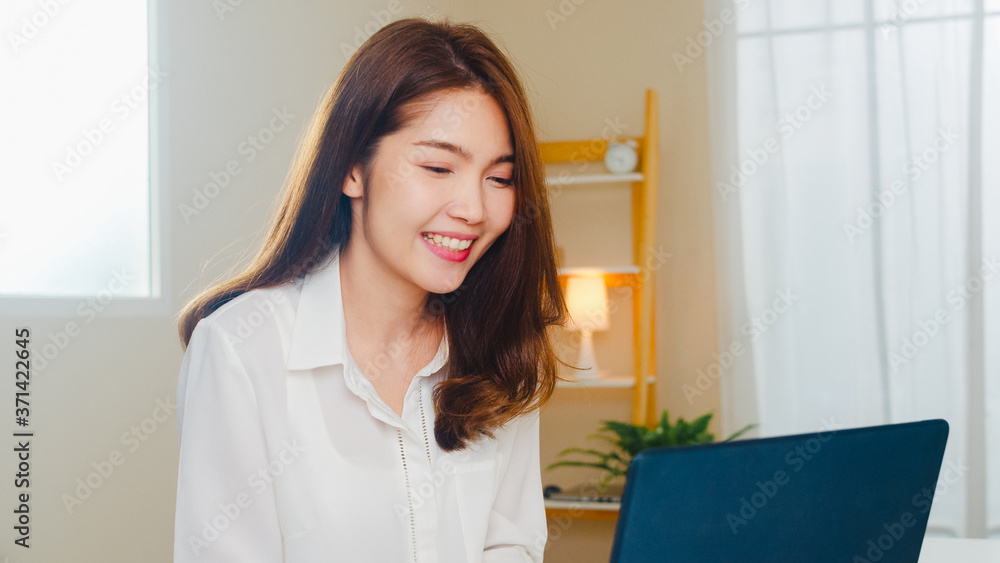 Young Asian business female using laptop video call talking with couple while working from home at living room. Self-isolation, social distancing, quarantine for coronavirus in next normal concept. Young Asian business female using laptop video call talking with couple while working from home at living room. Self-isolation, social distancing, quarantine for coronavirus in next normal concept.