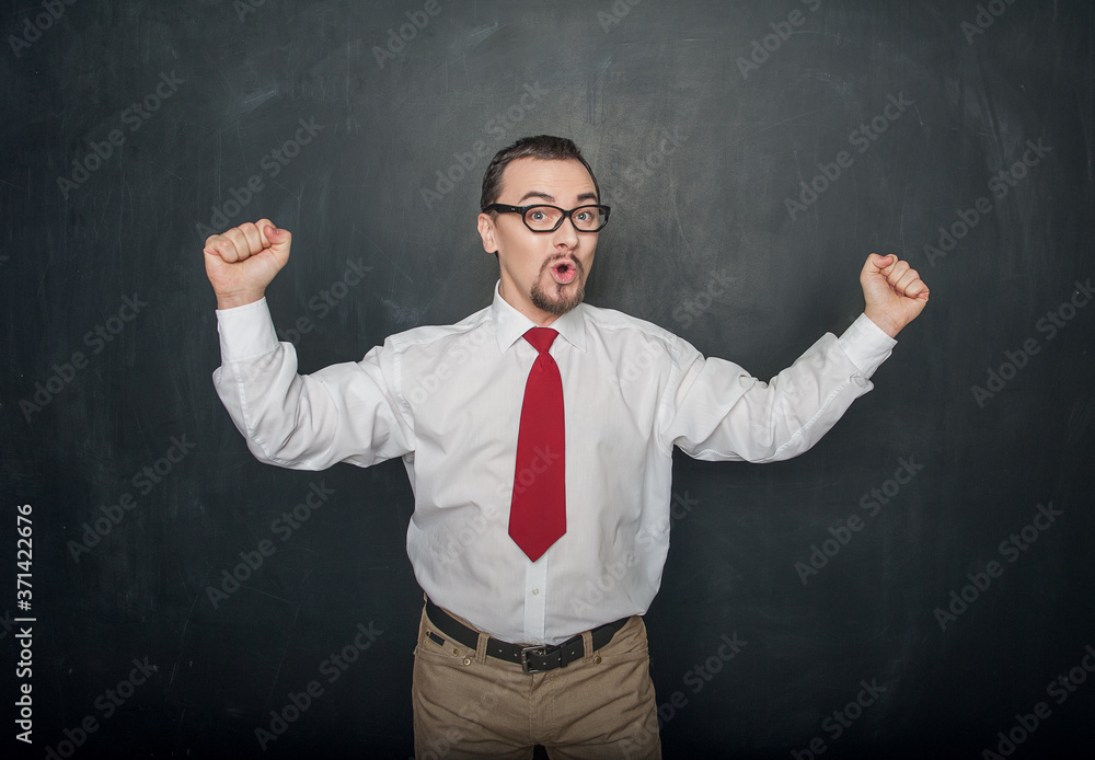 Successful handsome happy man with raising arms on chalkboard Successful handsome happy man with raising arms on chalkboard