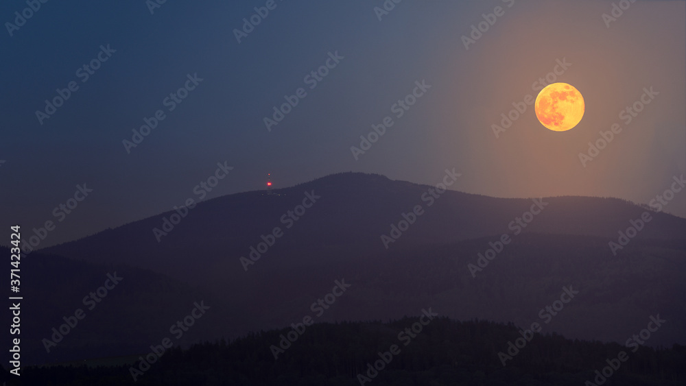Fototapeta premium The full flower moon - May, 07, 2020. The rising moon over the mountain peaks of the Sudetes.