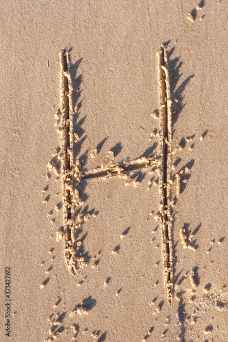 H - Alphabet letter written on sand 