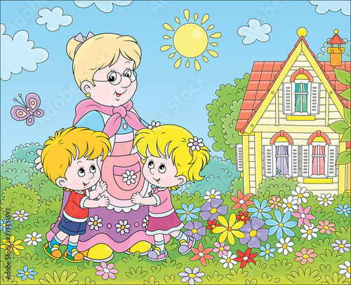 Granny and her little grandchildren smiling and hugging among colorful flowers on a green lawn in front of a village house on a sunny summer day, vector cartoon illustration