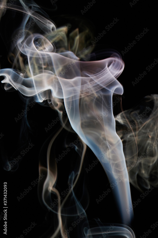 Fototapeta premium Yellow smoke swirls on black background
