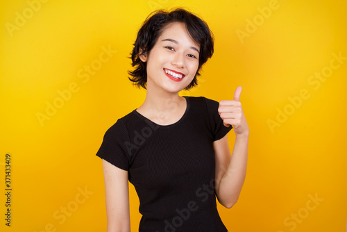 Good job! Portrait of a happy smiling blue eyed young successful woman giving thumb up gesture standing outdoors. Positive human emotion facial expression body language. Funny girl