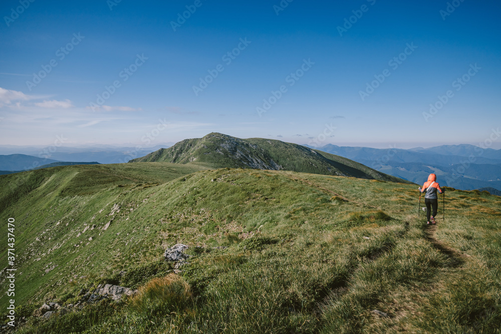 A group of people walking on a grassy hill A group of people walking on a grassy hill