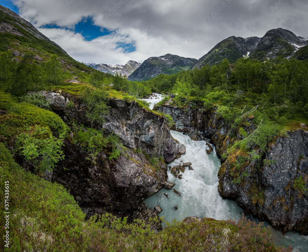 Intens green and lush mountain valley landscape with glacial river in Austerdalen Norway Intens green and lush mountain valley landscape with glacial river in Austerdalen Norway