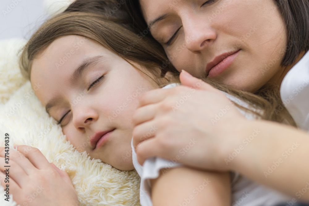 Close up of faces of mother and daughter sleeping together. Close up of faces of mother and daughter sleeping together.