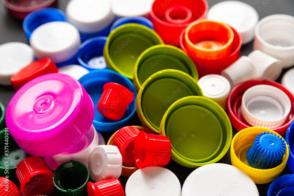 Top view of colored PET caps. Recycled plastic bottle caps. Separate garbage collection. Recycling of plastic for prosthetics. Selective focus. Top view of colored PET caps. Recycled plastic bottle caps. Separate garbage collection. Recycling of plastic for prosthetics. Selective focus.